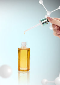 Anti-aging cosmetics oil for skin among molecules. Over gray background.