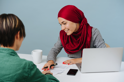 beautiful smiling muslim woman working on a laptop